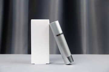 white and gray packaging for cosmetics on a gray background