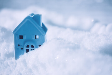 Blue monday concept with small house on cold winter snow background. Blue Monday in January the most depressing day of the year. Sad, loneliness, depression concept