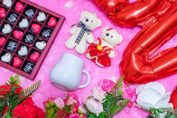 White blank milk mug on the top of a fluffy pink carpet surrounded by valentine themed decorations