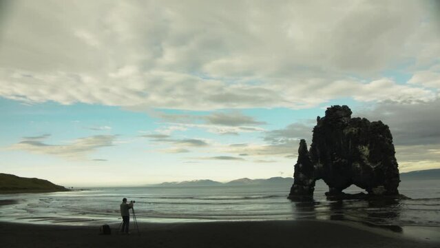Person taking photographs with tripod on beautiful coast of Iceland