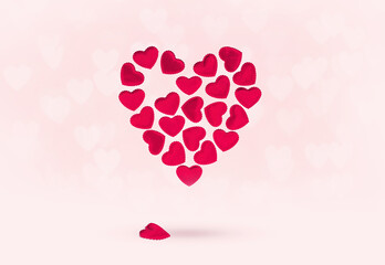St Valentines day or thank you concept. Many magenta red hearts form bigger heart shape floating on pink. One heart falled out. Love or wedding concept . Heartache. Separation cure