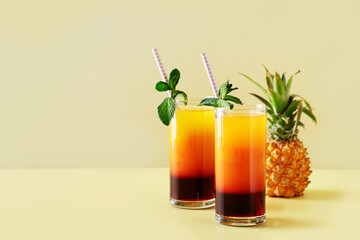 Pineapple summer drink cocktail with straw, mint leaf and fruit