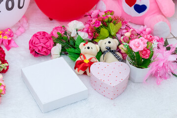 White blank rectangle box above a a fluffy white carpet surrounded by valentine themed decorations