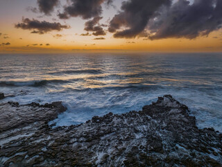 Surfs up sunrise at the seaside with scattered clouds