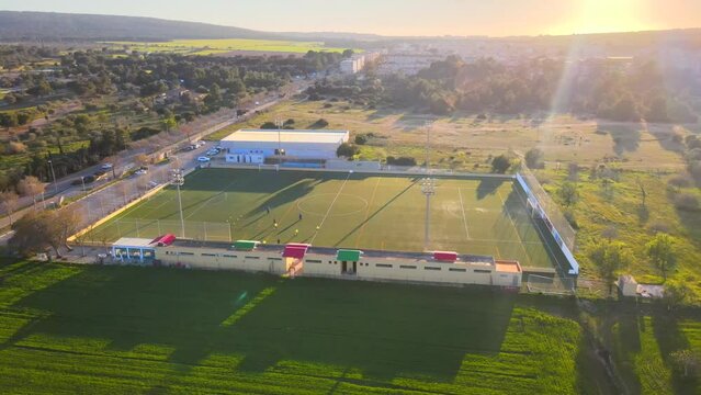 Panning rotating drone shot of a football field during golden hour in Santa Ponsa, Mallorca, Spain.