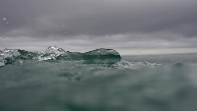 Point of view being in distress in the water of deep ocean, sinking below and coming back up.