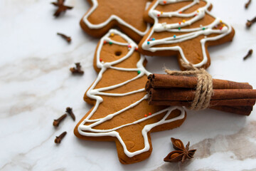festive gingerbread and spices lie on a light marble background. Top view