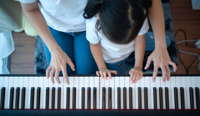 Family vacation, other helping daughter practice in her piano lessons © Wosunan