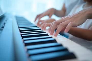 Family vacation, father and mother helping daughter practice in her piano lessons