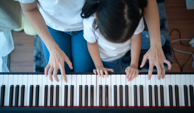 Family vacation, other helping daughter practice in her piano lessons