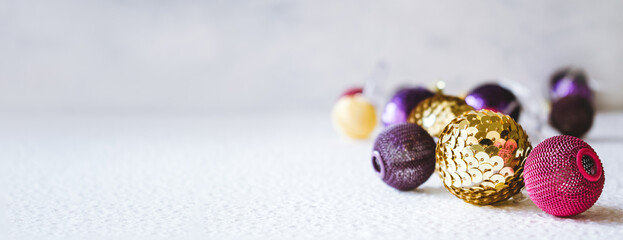 Christmas holiday festive theme with golden pink violet ball LED garland and gold and purple Christmas ornament. Xmas composition decoration, copy space