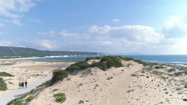 Aerial view flying over natural dunes and beach of Los Canos de Meca in Spain