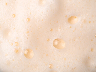 Foam texture extreme close up as background. Milkshake or cappucino foam with bubbles macro shoot....