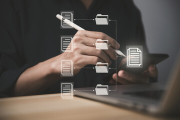 Businessman managing electronic documents on the laptop and smartphone.