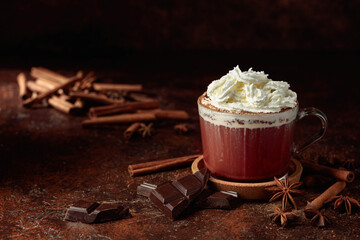Hot chocolate with ingredients on a brown table.