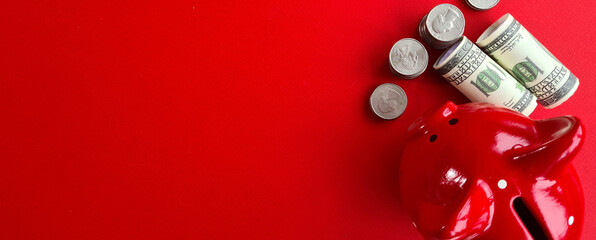 Piggy bank coins and money on a red background top view