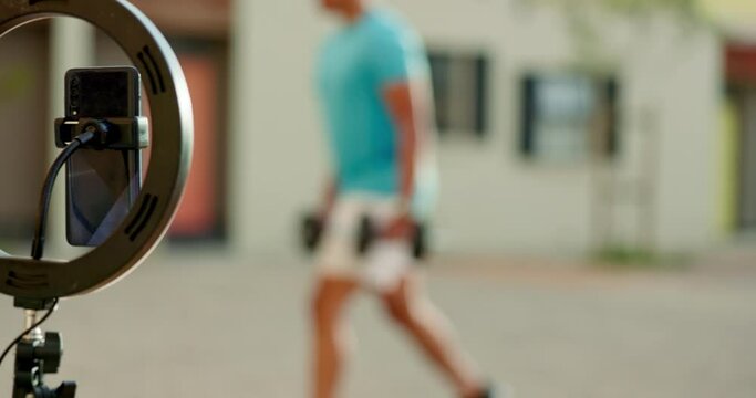 Ring light, fitness and live streaming on a mobile, exercise and gym workout for content creator. Sports training influencer filming for social media, blog and internet with phone for virtual class