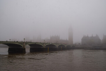 Obscured Houses of Parliament, Big Ben and Westminster Bridge  as thick fog covers London