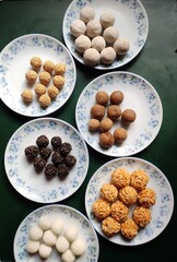 Round shaped desserts prepared by Assamese community in India called Laaru. Ingredients used are coconut, sesame, rice flour, puffed rice etc. These are prepared during Bihu festival in Assam, India.