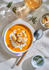 Pumpkin traditional soup with creamy silky texture with croutons. Grey background. Top view
