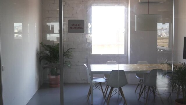 Shot of an empty meeting room with a sign saying 'sala de reuniones' .
