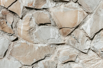 Stone wall background. Bumpy beige stone surface.