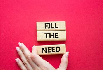 Fill the need symbol. Concept word Fill the need on wooden blocks. Beautiful red background. Businessman hand. Business and Fill the need concept. Copy space