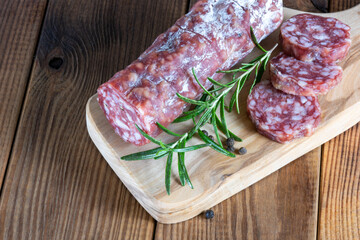cutting board with sliced salami on it.