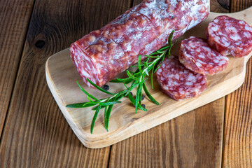 cutting board with sliced salami on it.