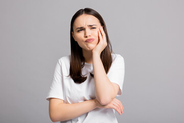 Crying tired sad woman suffers from painful toothache dental illness pointing on teeth standing on...