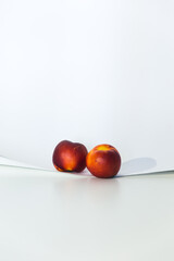 Bodegón moderno actual minimalista con frutas rojas con fondo blanco limpio con luz y sombra