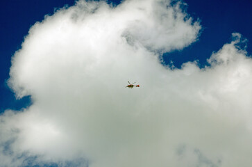 London Air Ambulance flying overhead on a sunny day - 555080668
