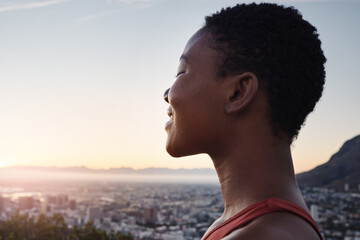 Fitness, sunset and black woman in the city with freedom, zen and calm after an outdoor workout. Sports, training and African female athlete doing a wellness exercise in a urban town in the evening.