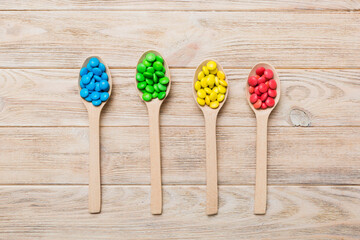 delicious colorful sweet candies on spoon on colored background . Confectionery decor top view with copy space