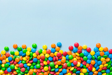 Mixed collection of colorful candy, on colored background. Flat lay, top view. frame of colorful chocolate coated candy