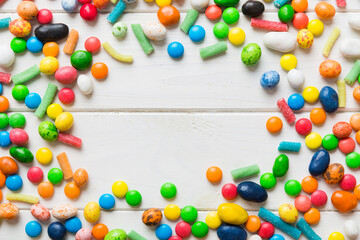 Mixed collection of colorful candy, on colored background. Flat lay, top view. frame of colorful chocolate coated candy