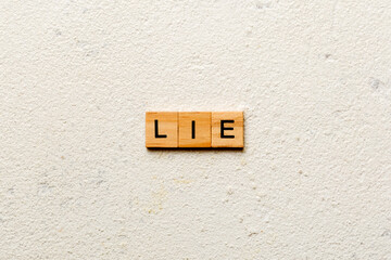 LIE word written on wood block. LIE text on cement table for your desing, concept