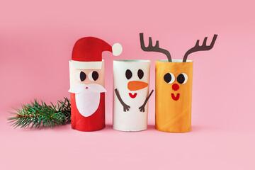 Christmas decoration for winter season. Holiday easy DIY craft idea for kids. Toilet paper roll tube toy. Santa snowman deer on pink background. eco-friendly, reuse, recycle handmade minimal concept