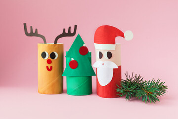 Christmas decoration for winter season. Holiday easy DIY craft idea for kids. Toilet paper roll tube toy. Santa snowman deer on pink background. eco-friendly, reuse, recycle handmade minimal concept