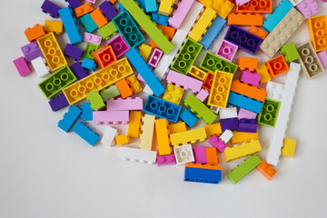 Multi-colored building blocks for children on a white background top view copy space
