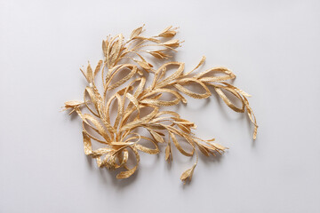 The branch with leaves is made of straw. Straw wall decoration. The products are made of straw. Decoration of straw on an white background