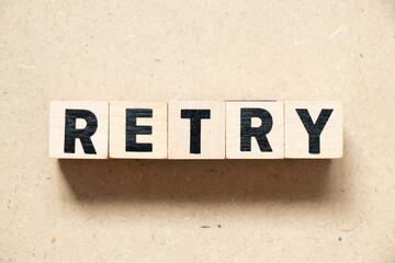 Alphabet letter block in word retry on wood background