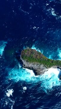 Vertical aerial video of bay with turquoise water and rocky islands with few bushes