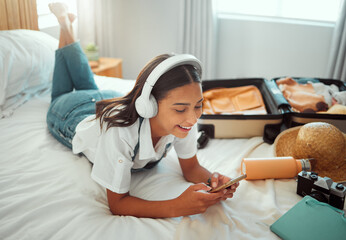 Obraz premium Social media, music and woman with phone on a holiday, travel communication and mobile app update. Podcast, internet and girl in a bedroom for freedom on vacation, streaming radio and typing on chat