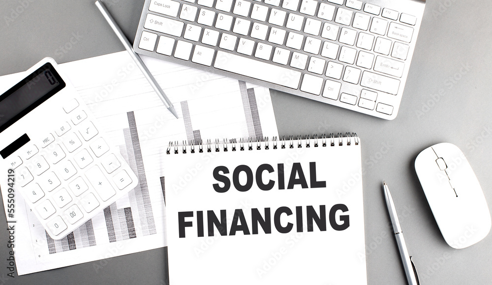 Poster social engaging text written on notebook on grey background with chart and keyboard , business conce