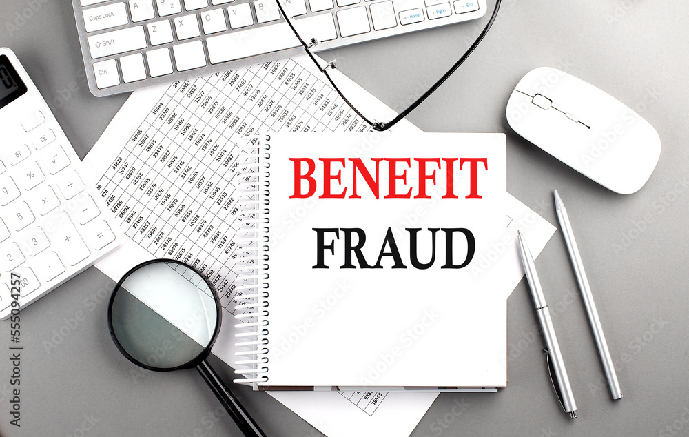 Aufkleber benefit fraud text on notepad on chart with keyboard and calculator on grey background