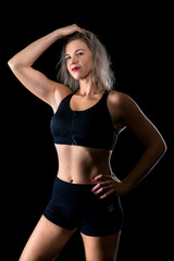 portrait of beautiful young fitness woman in studio with black background