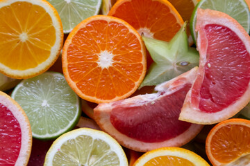 Sliced citrus fruits in different sizes and colors top view flat lay