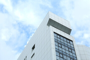 Modern office building against sky with clouds