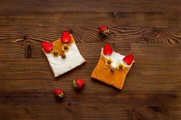 Kids breakfast with fox faces sandwiches made from peanut butter and strawberries